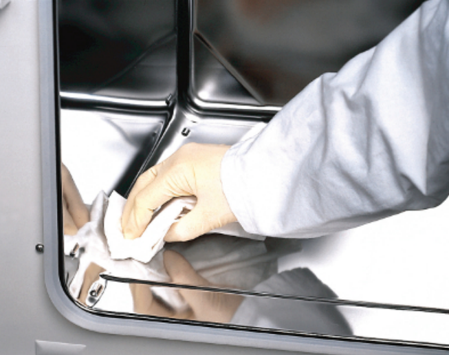 image of a gloved hand wiping down the inside of an incubator